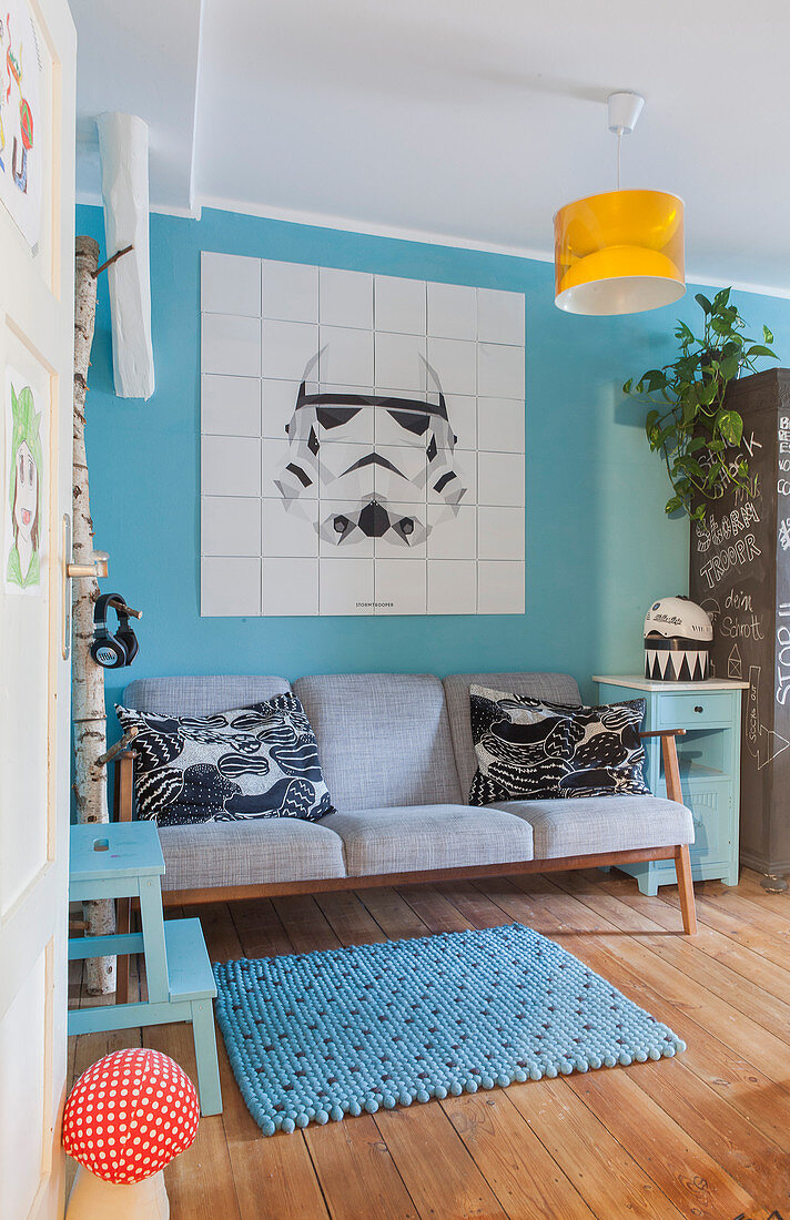 Star Wars image on tiles on light blue wall above retro sofa