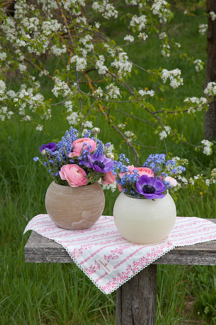 Spring flowers in spherical vases in garden