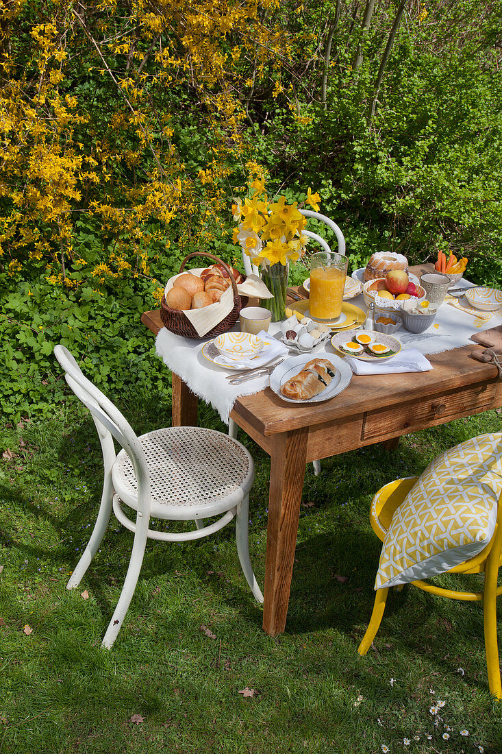 Fürs Osterfrühstück gedeckter Tisch im Garten