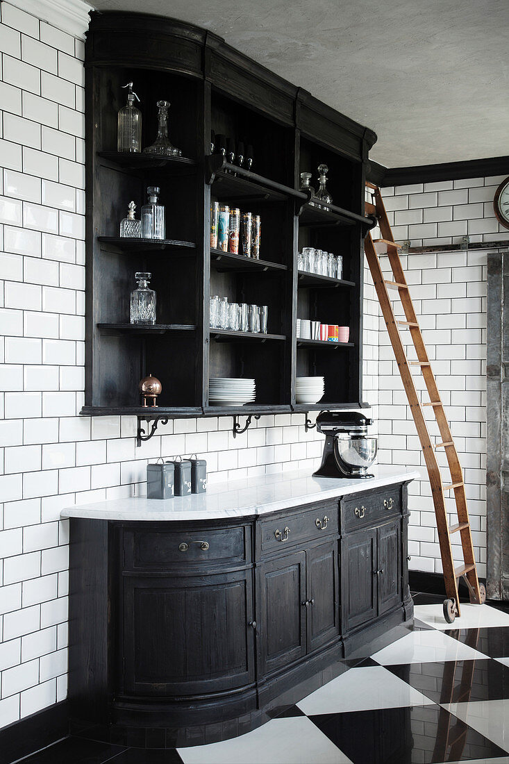 Black painted dresser made from repurposed bookcase on tiled wall in black and white kitchen
