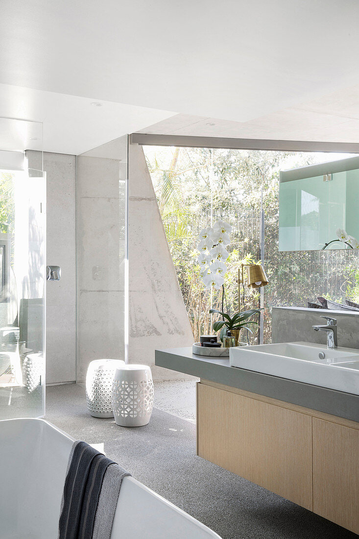 Modern bathroom with glass wall in concrete, architect-designed house