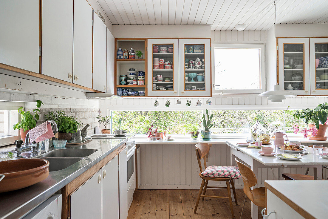 Gemütliche Wohnküche in Weiß mit umlaufendem Fensterband