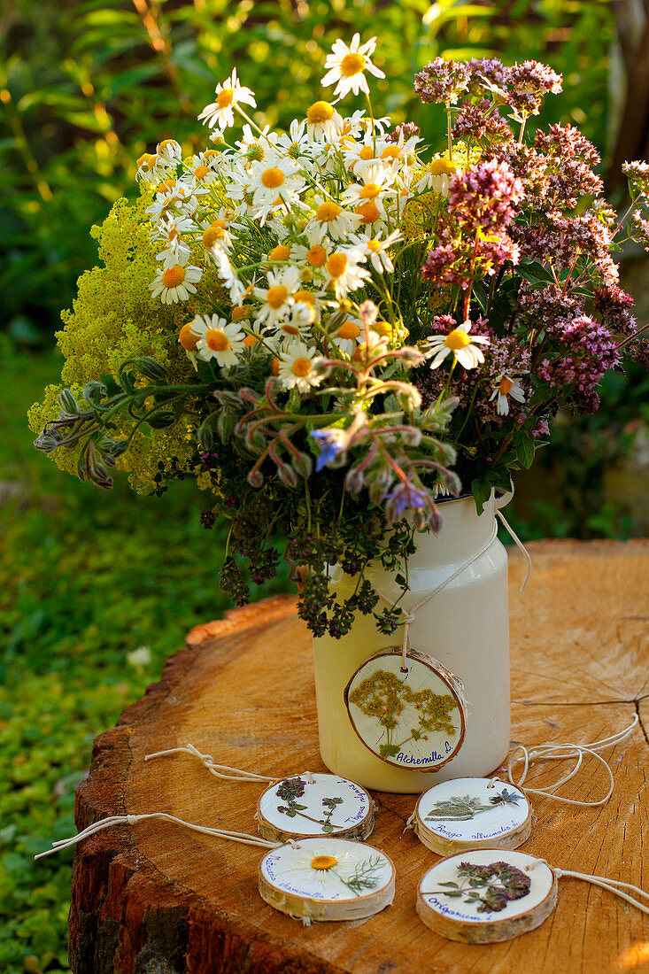 Kanne mit Kräuterblüten und Anhänger aus Holzscheiben