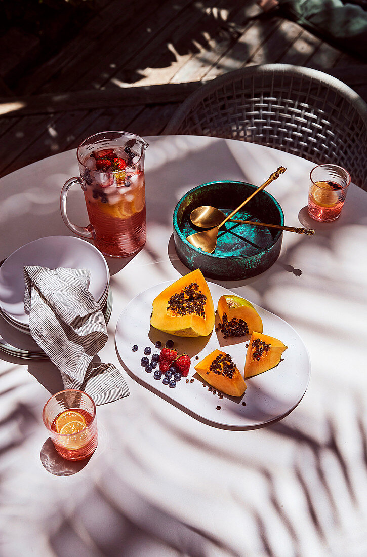 Papaya, Beeren und Erfrischungsgetränk auf dem Tisch im Freien