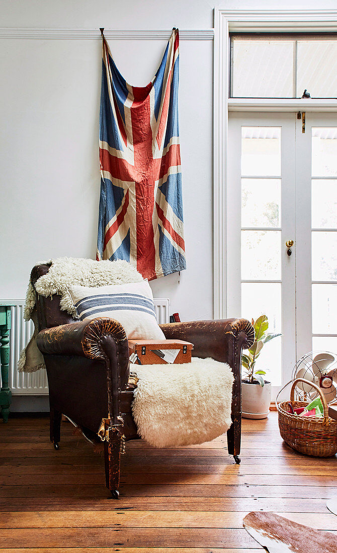 Vintage animal hide leather armchair in front of Union Jack flag on wall