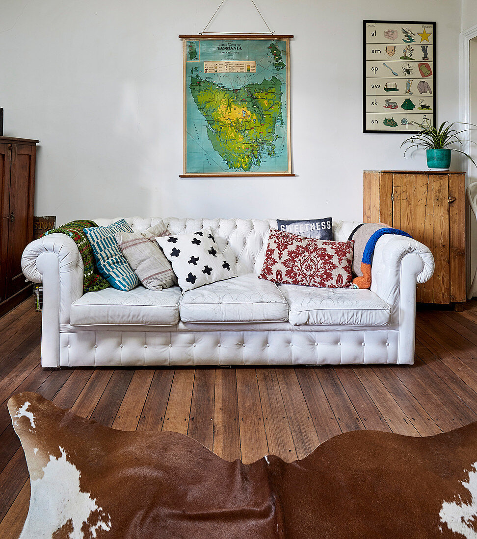 Vintage leather sofa in white with pillows and animal fur rug in the living room