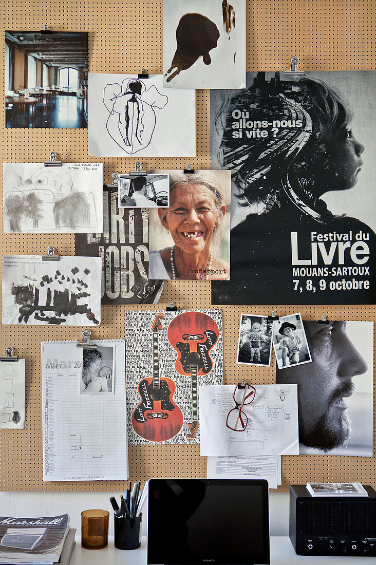 Plakat, Fotos und Zeichnungen an einer Pinnwand aus einem Lochbrett