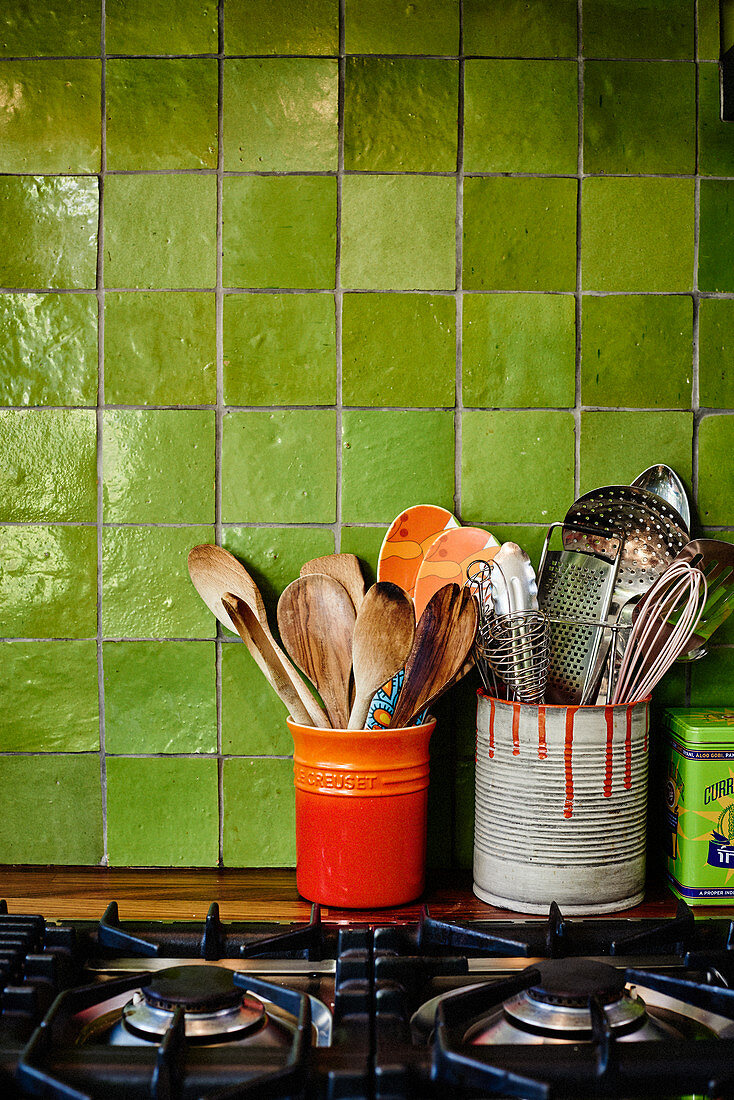 Cooking utensils in ceramic pots and painted tin cans