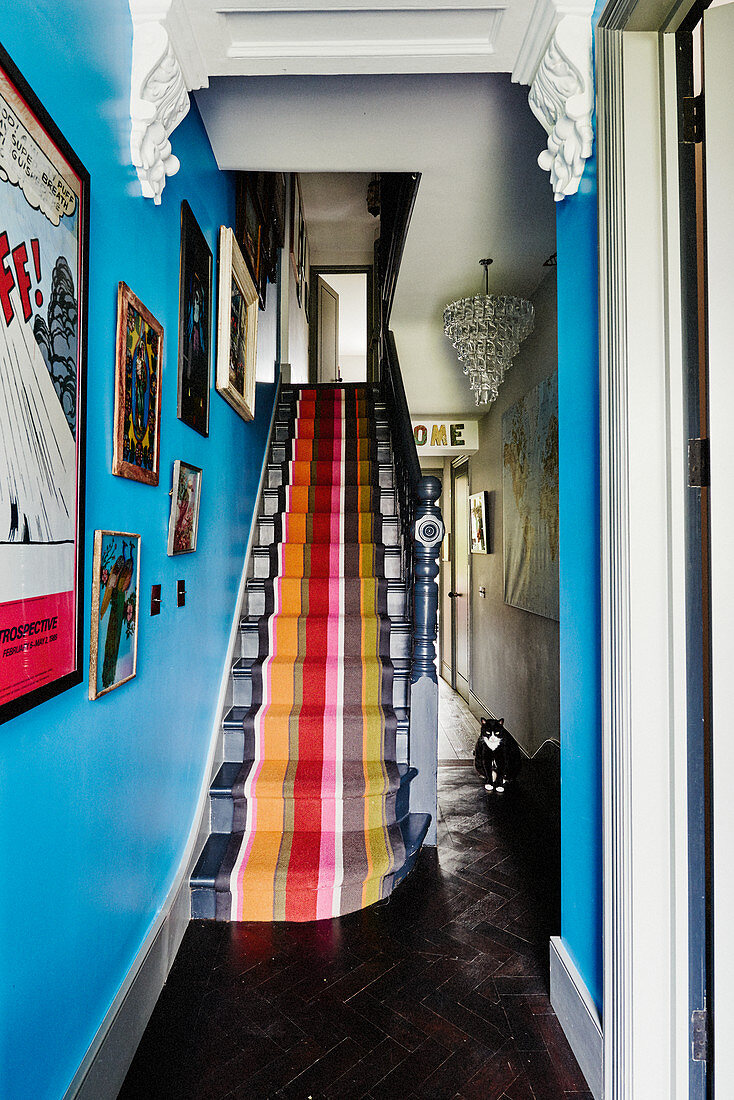 Bunt gestreifter Teppich auf der Treppe an blauer Wand