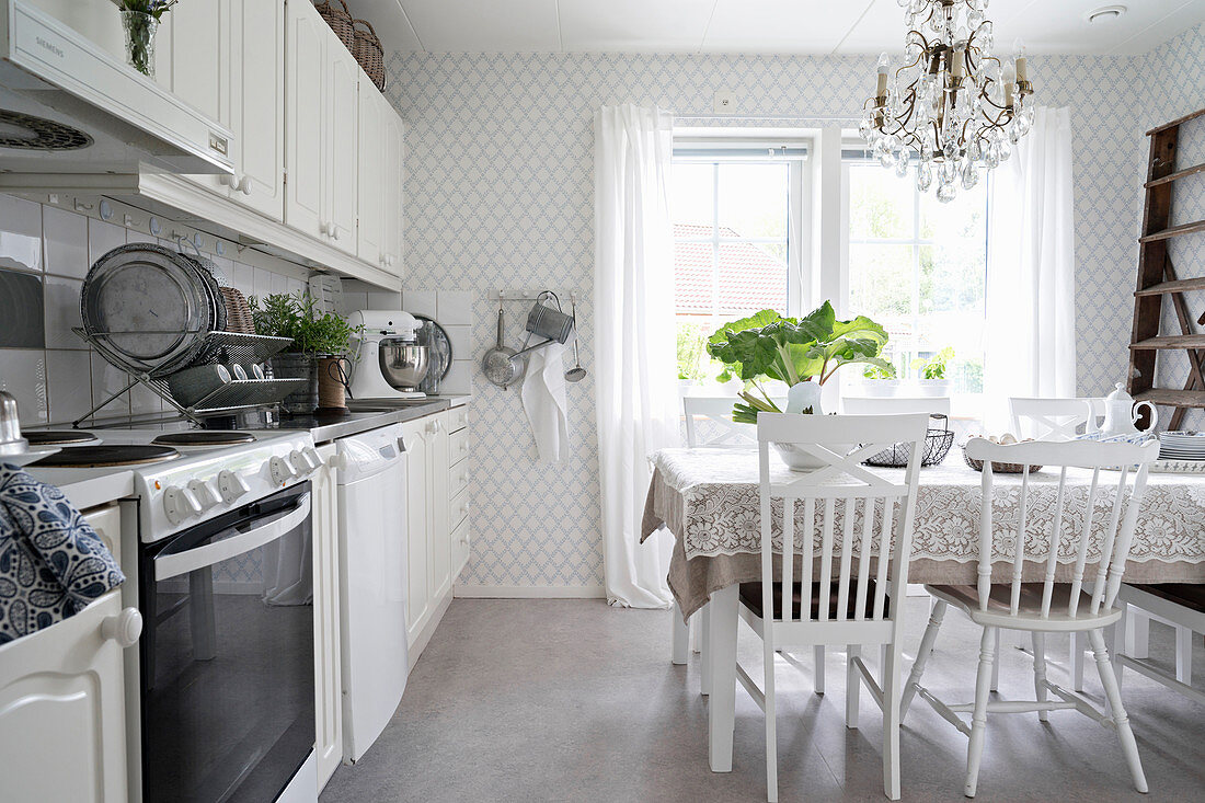 Dining table in vintage-style kitchen in white and grey