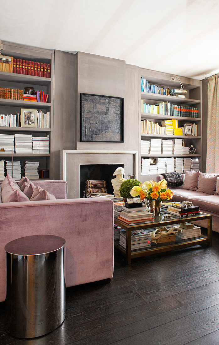 Two sofas opposite one another in front of open fireplace flanked by bookshelves