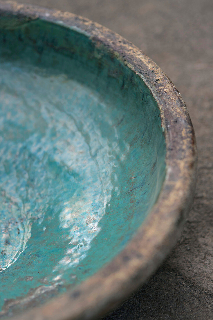Close-up of rustic stoneware dish with turquoise glaze