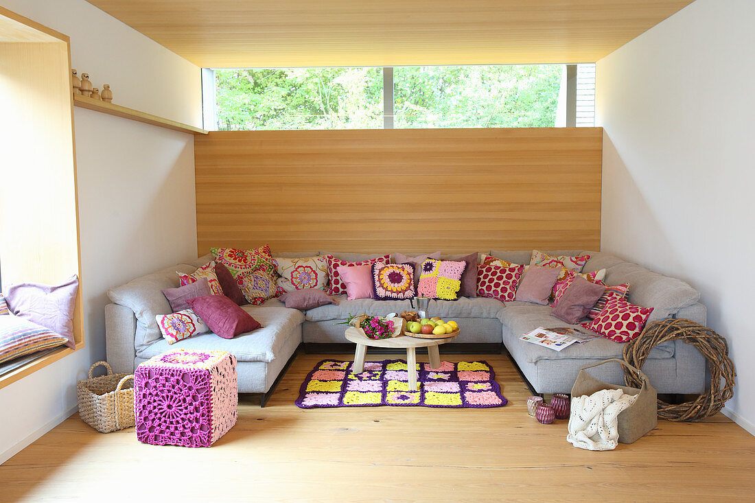 Bunte Kissen auf einem grauen Sofa im modernen Wohnzimmer