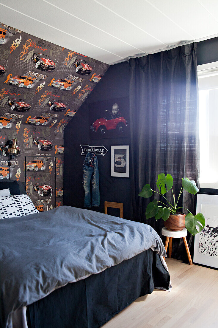 Car-patterned wallpaper and bed in teenager's beroom