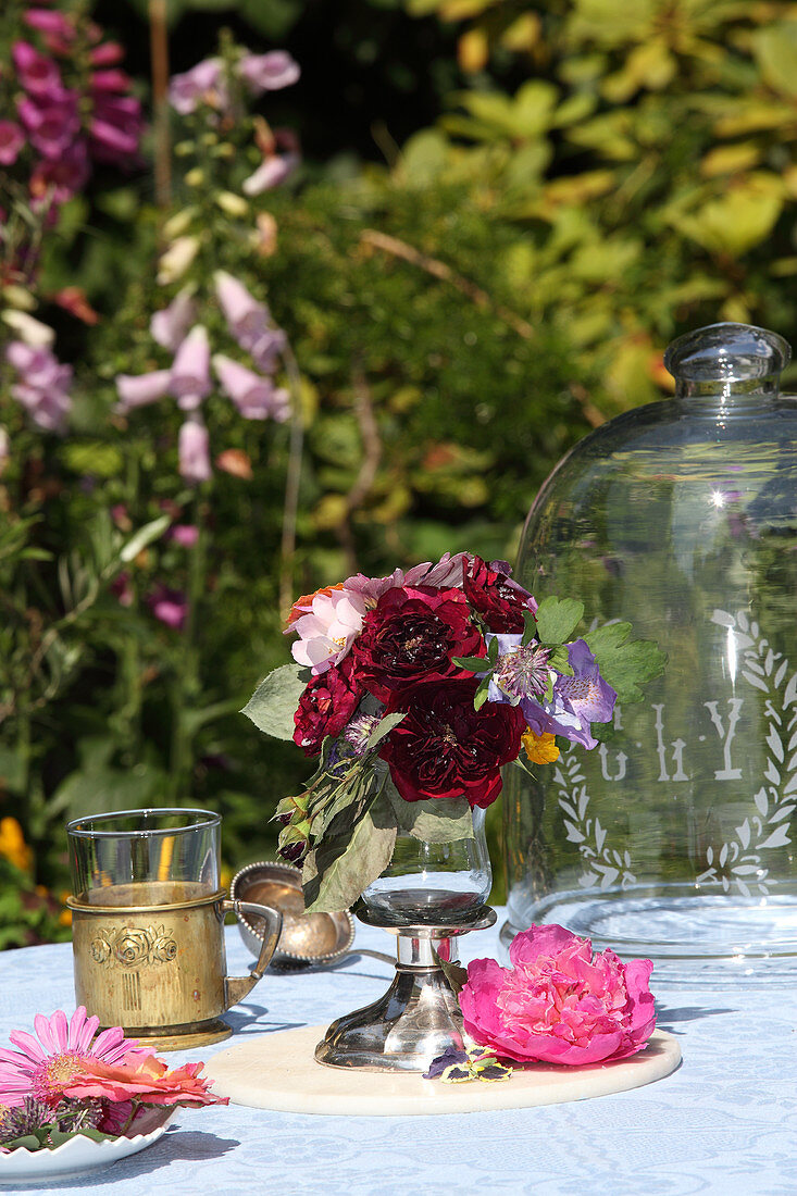 Posy in glass goblet on garden table