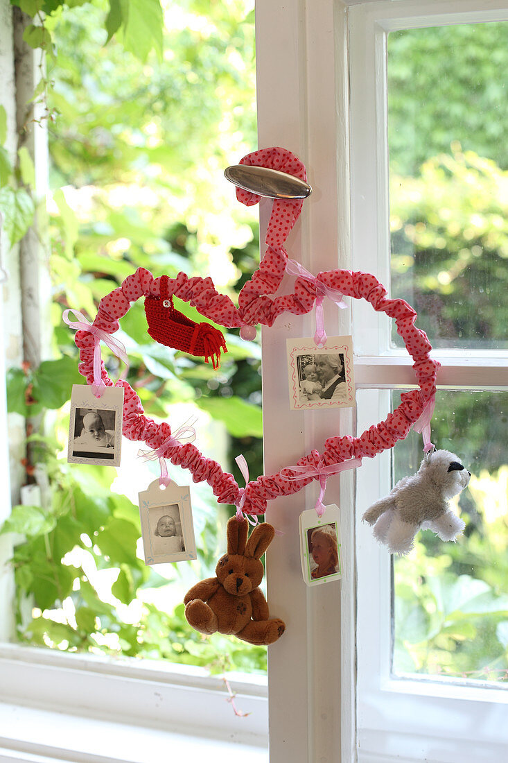 Mobile made from coat hanger bent into love heart and covered in red fabric