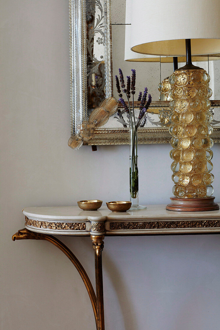 Elegante Konsole mit Tischlampe vor Wandspiegel mit Silberrahmen