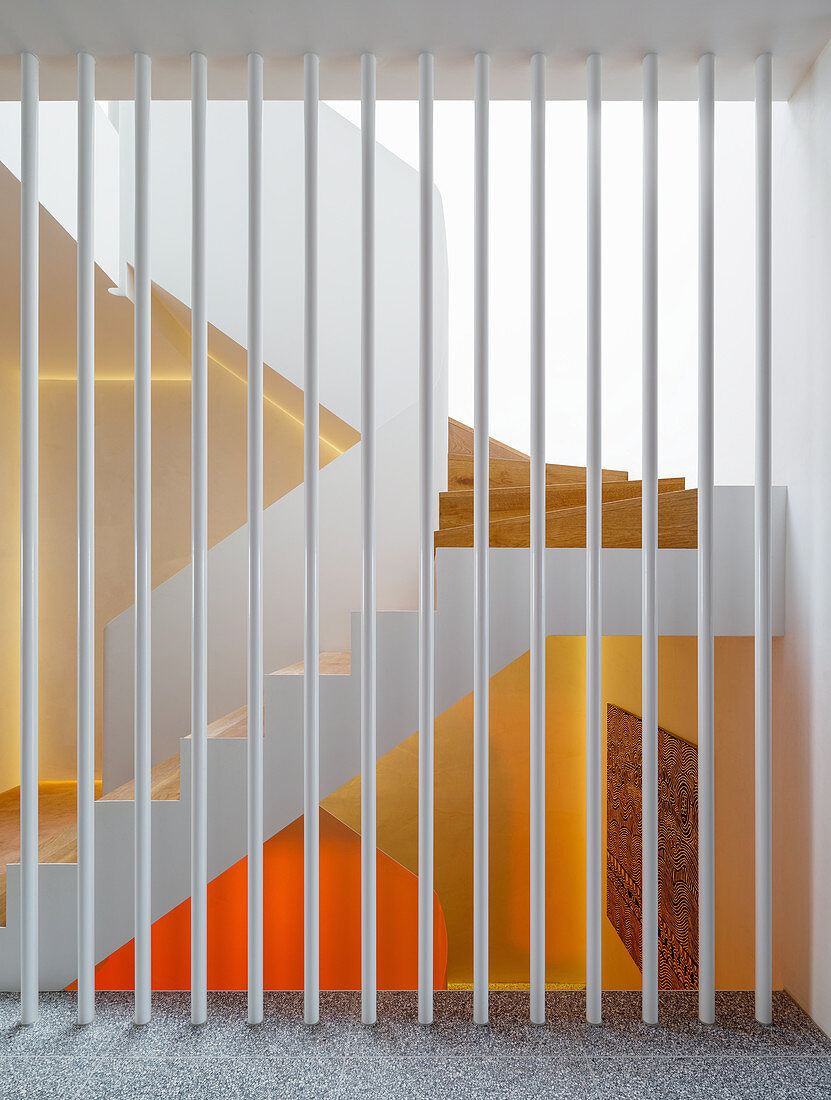 White painted metal bars as a room divider, view of the stairwell
