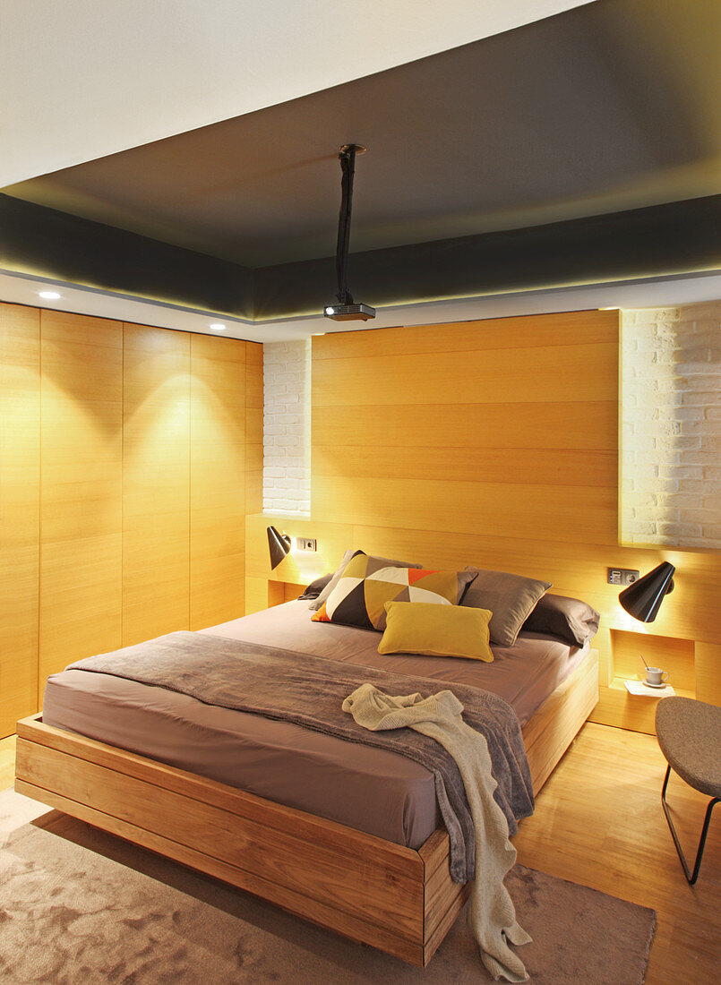 Schlafzimmer mit hellem Holz an Wandverkleidung und Schranktüren