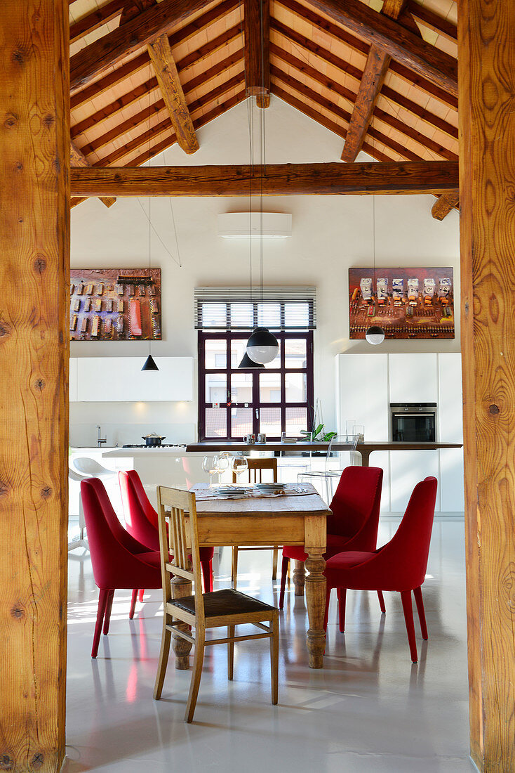 View through wooden columns into dining area and open-plan kitchen