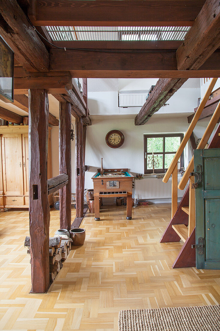Old football table in open-plan interior with wooden beams