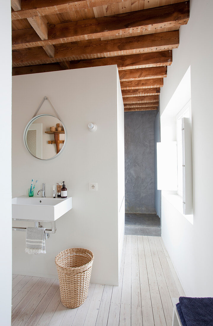 Simple white bathroom with wood-beamed ceiling