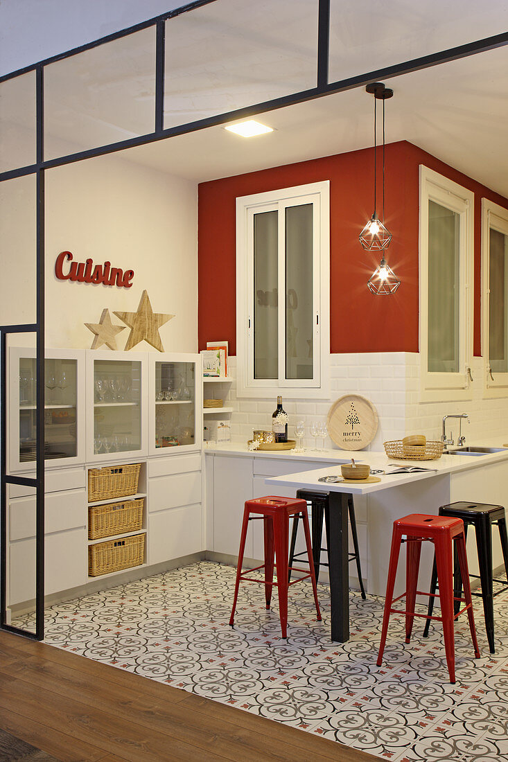 Open-plan kitchen in red, white and black with patterned floor
