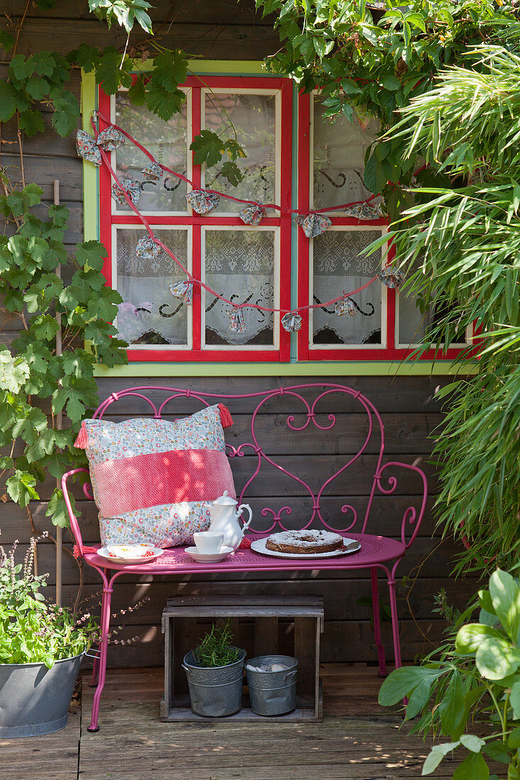 Romantischer Sitzplatz auf der Terrasse vor dem Gartenhaus
