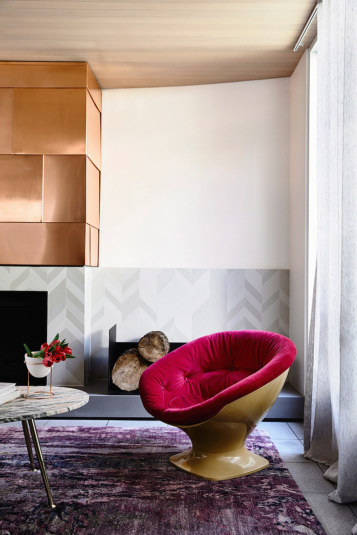 Designer-Sessel, Coffeetable und Kamin, darüber Kupferplatte im Wohnzimmer