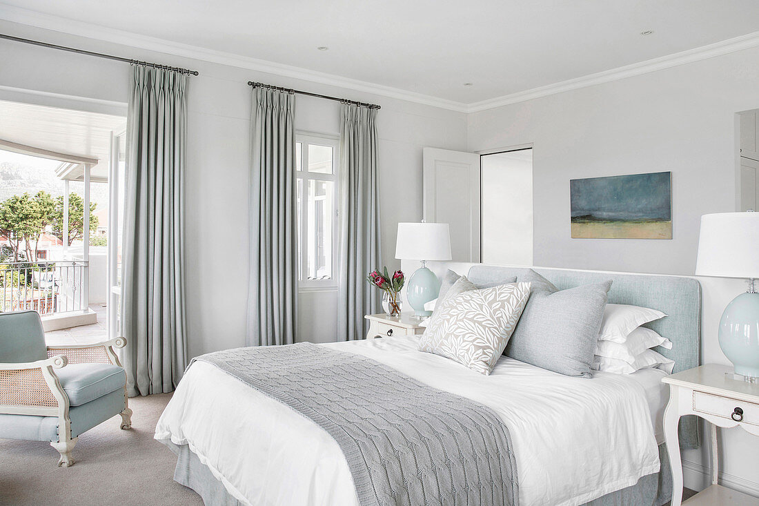Elegantes Schlafzimmer in Grau-Blau mit Raumteilerwand hinter dem Bett
