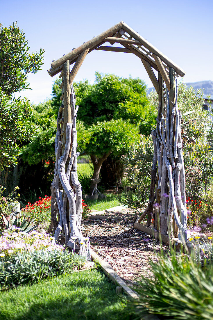 Wooden arch over path in exotic garden