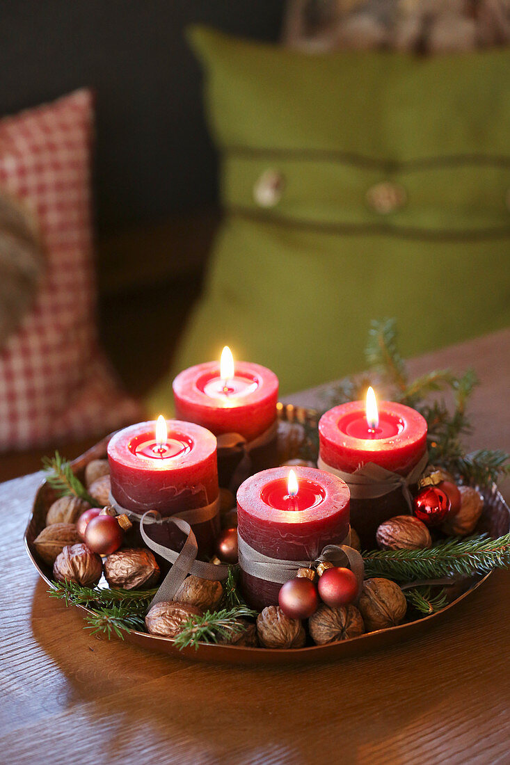 Advent candles, walnuts and conifer sprigs in dish