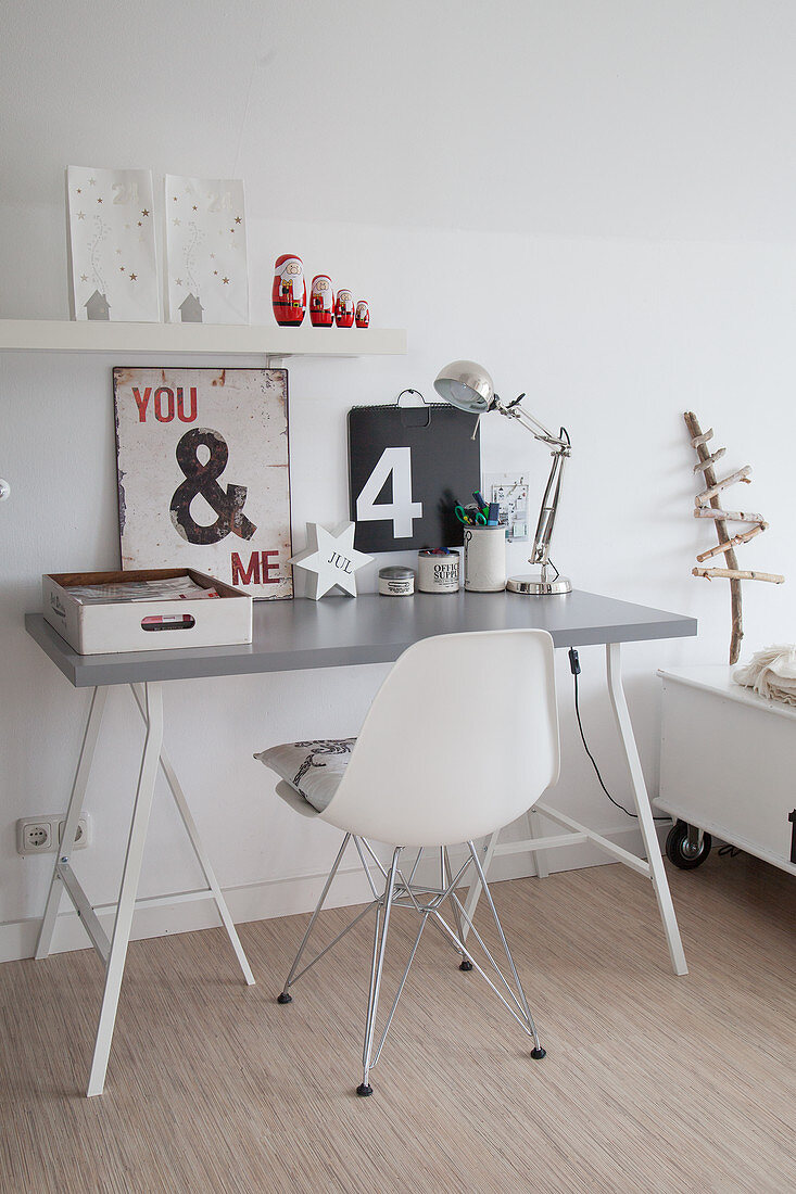 Vintage signs and lamp on simple desk with grey top and classic chair