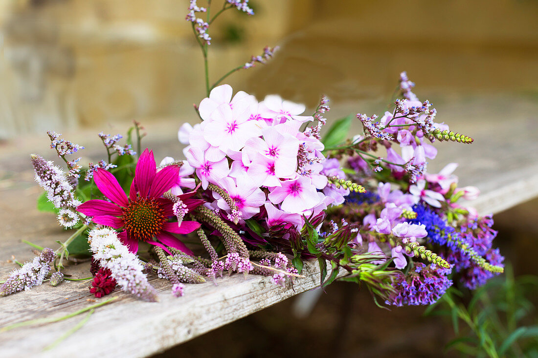 Summer bouquet with phlox and echinacea on wooden bench