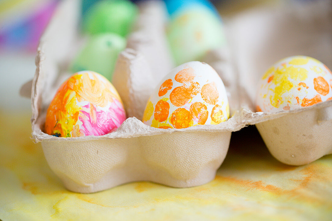Mit Gouache-Farben bemalte Ostereier im Eierkarton
