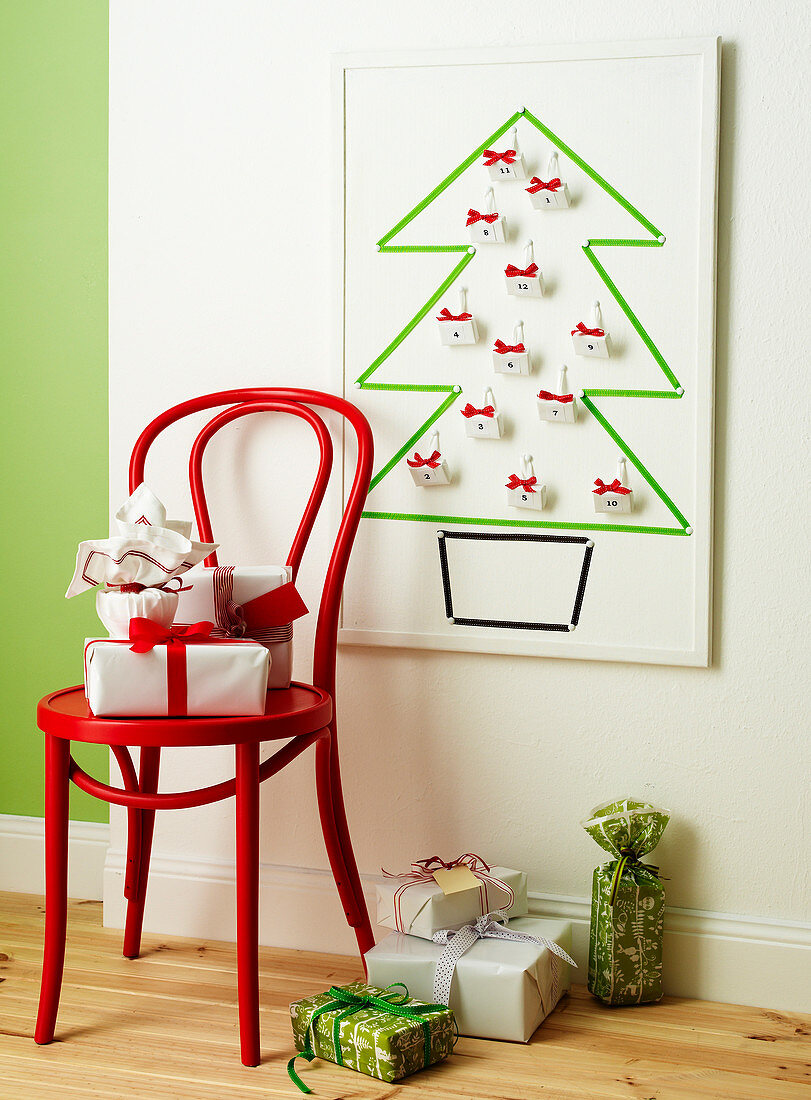 Stuhl mit Geschenken vor Adventskalender in Tannenbaumform