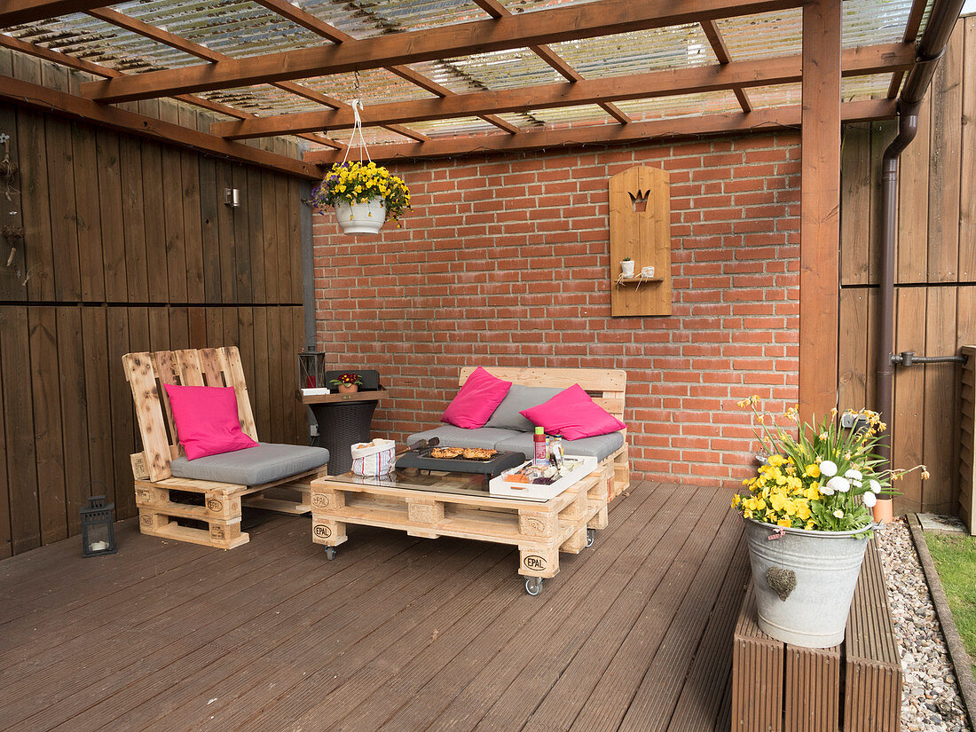 Table and chairs made from pallets on roofed terrace