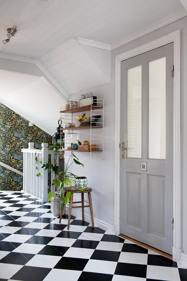 White wood panelling and chequered floor in bright hallway