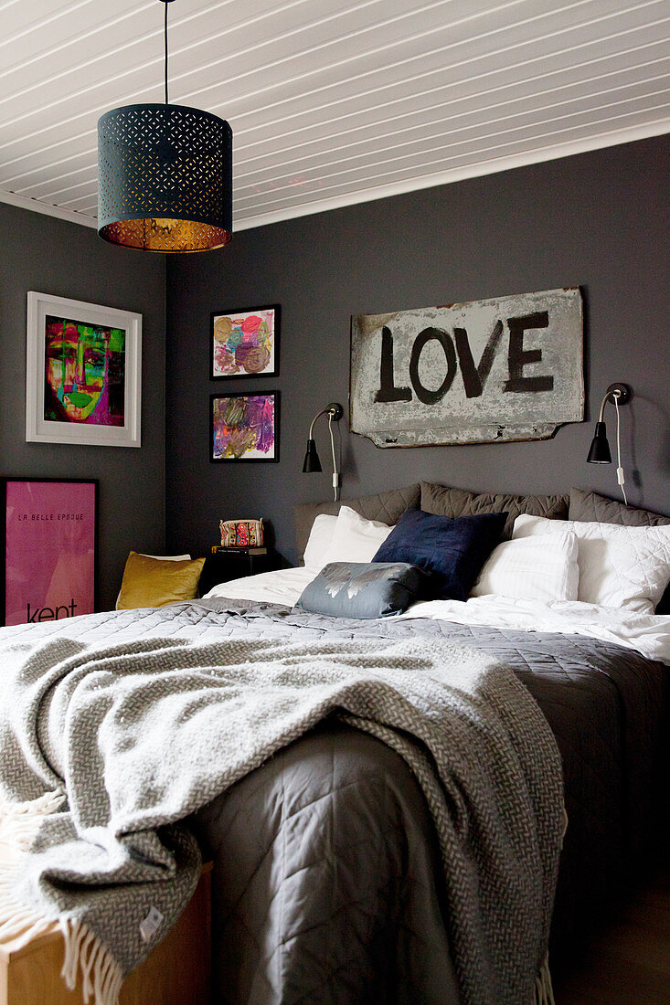 Schlafzimmer in Grau mit Schriftbild über dem Bett
