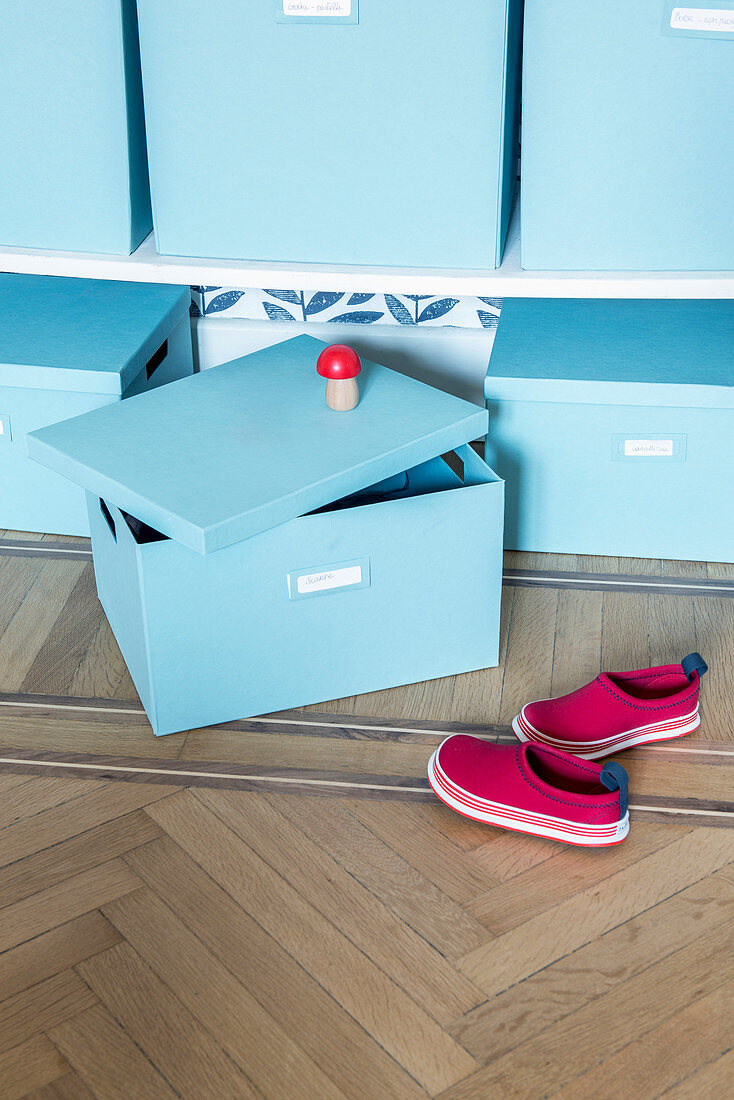 Pale blue storage boxes and child's shoes