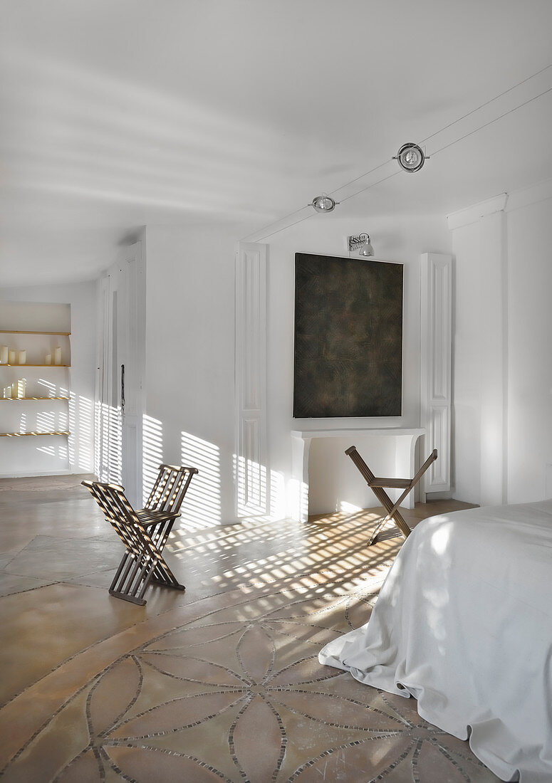 X-chairs in white bedroom flooded with sunlight