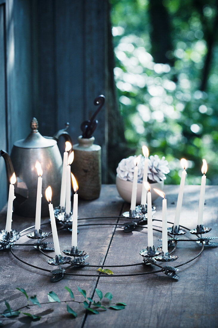 Kranz mit Kerzenklammern und dünnen weißen Kerzen