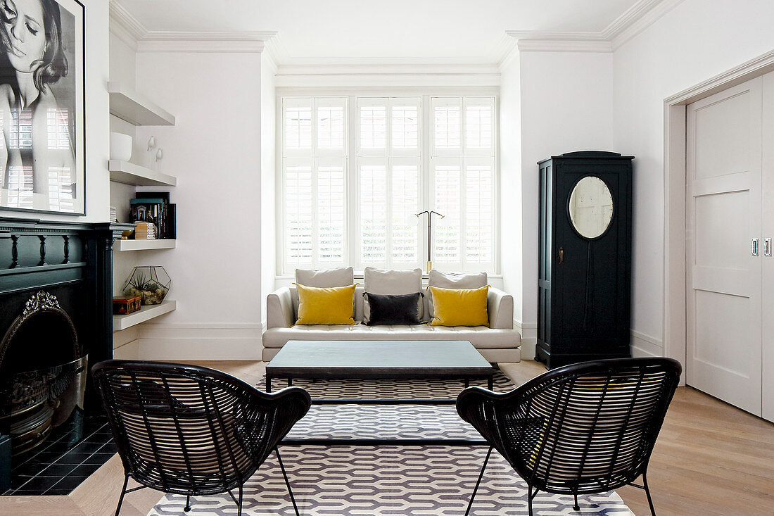 Black-and-white living room with two yellow scatter cushions on sofa