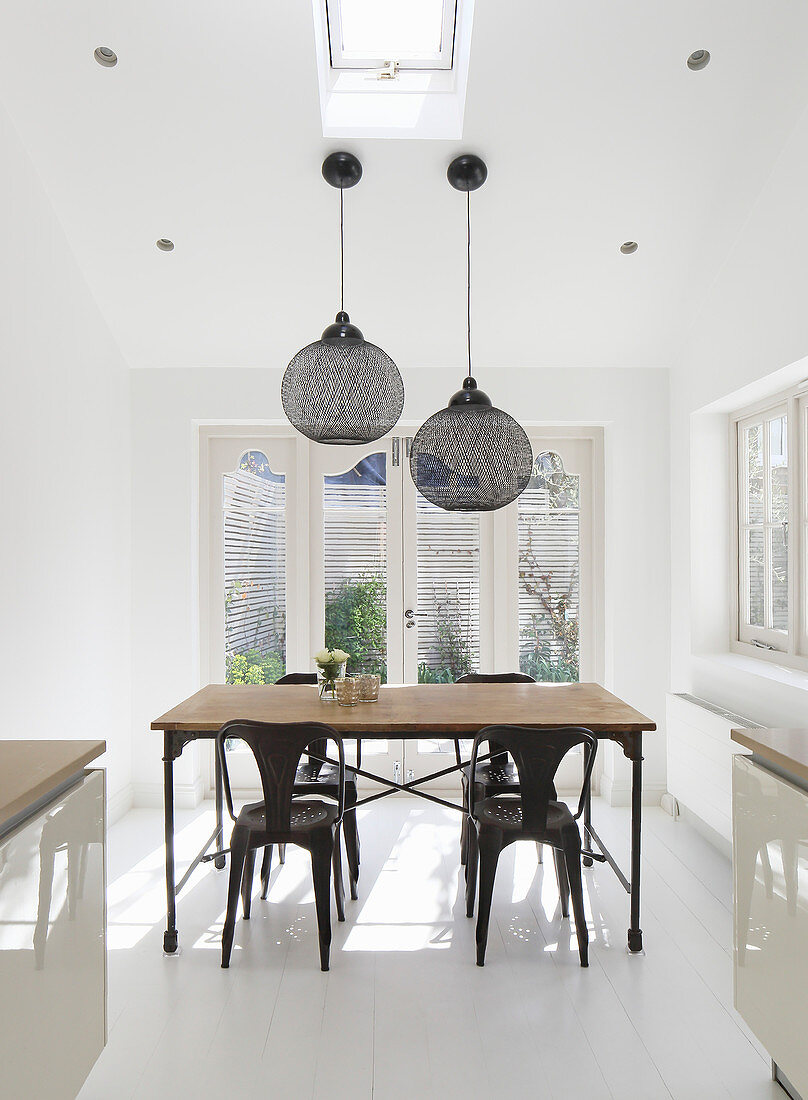 Industrial-style table and chairs in white dining room