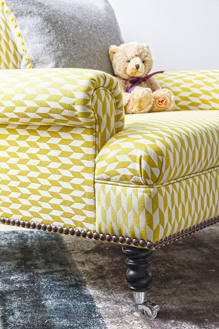 Teddy auf dem Sessel mit grafisch gemustertem Bezug in Gelb-Weiß