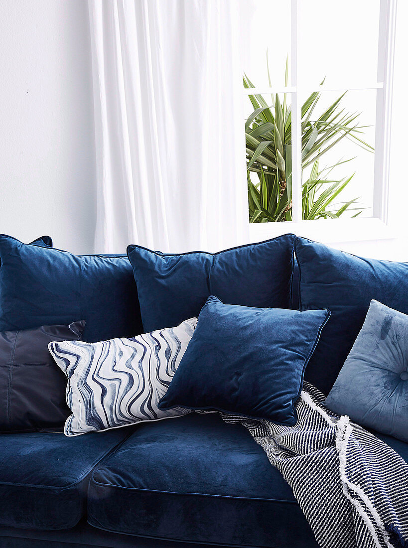 Blue upholstered sofa with pillow collection