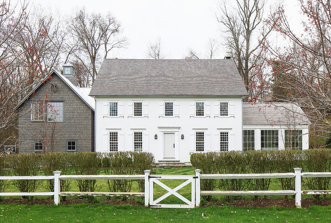Fence and hedge surrounding American farmhouse