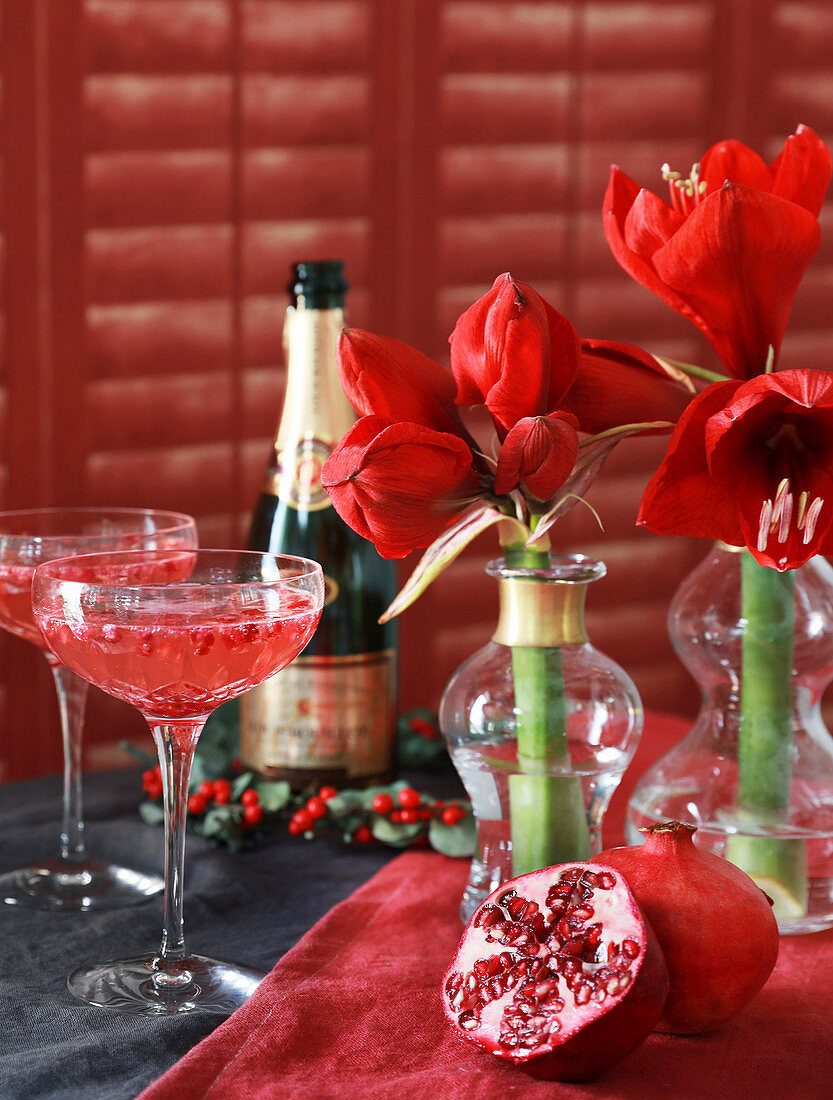 Champagne saucers, pomegranate and amaryllis on set table