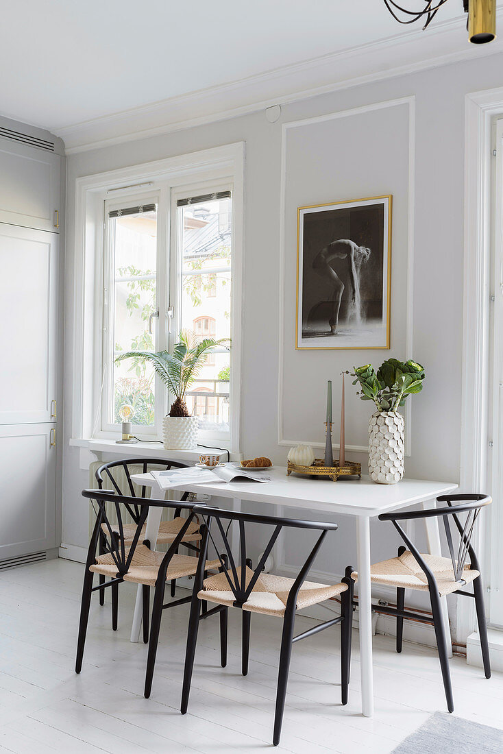 Weißer Esstisch mit Stühlen in heller Küche