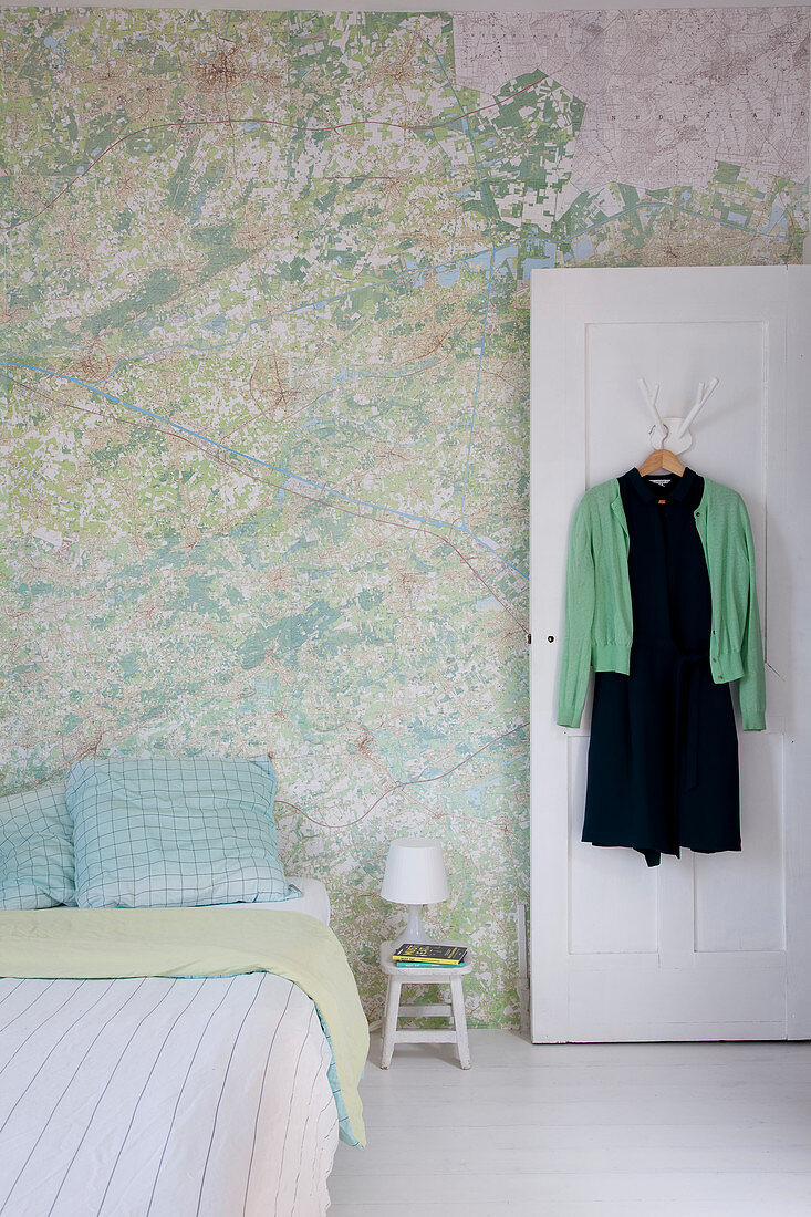 Bett im Schlafzimmer mit Landkarten-Tapete